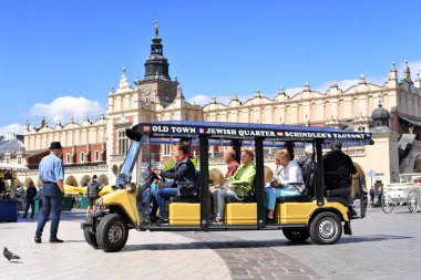 Krakow, Cumhuriyeti Polonya-Temmuz 3, 2017: Main Market Square üzerinde Antik Krakow aracılığıyla ekkursiy için bir araba. Krakow, Cumhuriyeti Polonya-Temmuz 3, 2017: Ekkursiy antik Krakow şehir sokaklarında aracılığıyla bir araba.