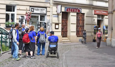 Prague, Çek Cumhuriyeti 1 Mayıs 2017: bir rehber (Kazimierz Yahudi bölgesinde Sinagogu, kentin antik sokaklarda turist organize grup).