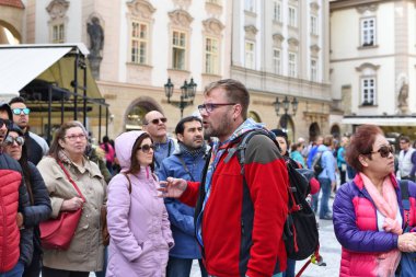 PRAGUE, CZECH REPUBLIC  May 1, 2017: Organized group of tourists with a guide on the ancient streets of the city.