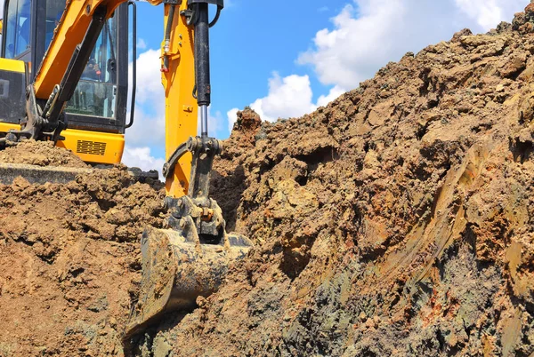 The modern excavator  performs excavation work on the construction site