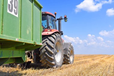 Kalush, Ukrayna 20 Temmuz 2018: Modern traktör şehrin Kalush, Ukrayna tahıl hasat için bir römork ile.