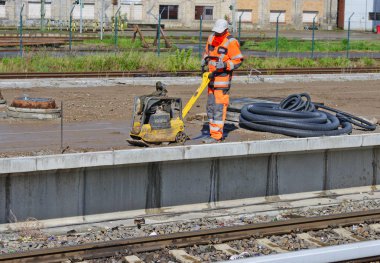 Berlin, Almanya Federal Cumhuriyeti - 27 Nisan 2018: builder Wacker Neuson marka plaka titreşimli tersinir yardımı ile beton sıvı düzenler.