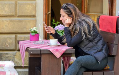 Prague, Çek Cumhuriyeti - 2 Mayıs 2018: bir fincan kahve eski bir sokakta bir restoran masada bir kızla.