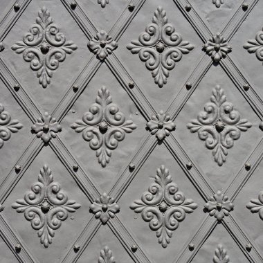 Üzerinde demir dövülmüş elementler olan antik bir binanın ön metal kapısı..