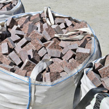 İnşaat alanında granit bloklu esnek orta büyüklükte bir konteynır (Fibc).