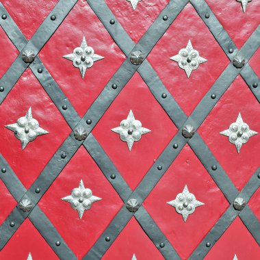 Üzerinde demir dövülmüş elementler olan antik bir binanın ön metal kapısı..