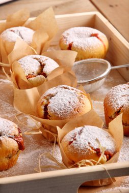 Taze pişmiş reçel muffins ahşap zemin üzerine pudra şekeri tepesi ile