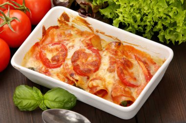 Caneloni Etli dolma ve grunge ahşap arka plan üzerinde beyaz kase beyaz peynir erimiş