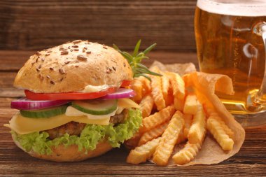 Hamburger sebze, patates ve bira tablo ile