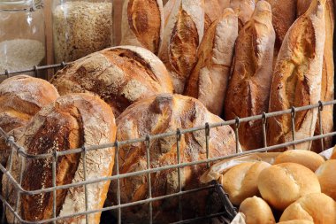 Ekmek ve ahşap arka plan üzerinde metal bir sepet buns farklı