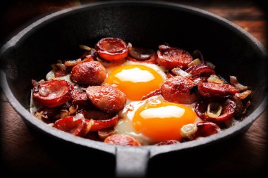 Pişmiş yumurta ve sosis rying Pan, lezzetli İngiliz kahvaltısı ahşap arka plan üzerinde