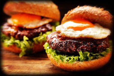 Sığır eti ve taze sebze ahşap arka plan üzerinde hamburger, vintage yakından vie