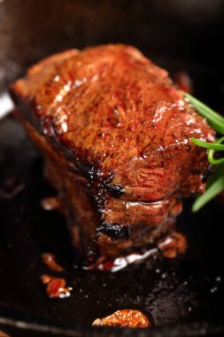 Dökme demir tava tava üzerinde sulu biftek biftek ve otlar baharat 
