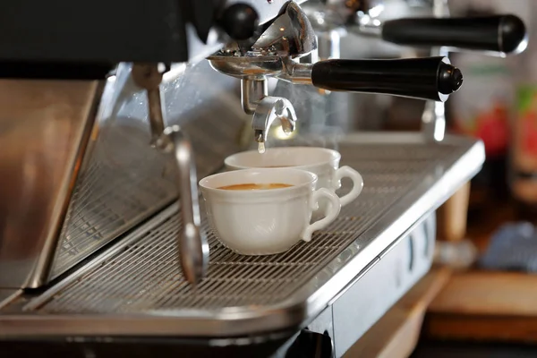 Closeup of espresso machine making cappucino cup of coffe