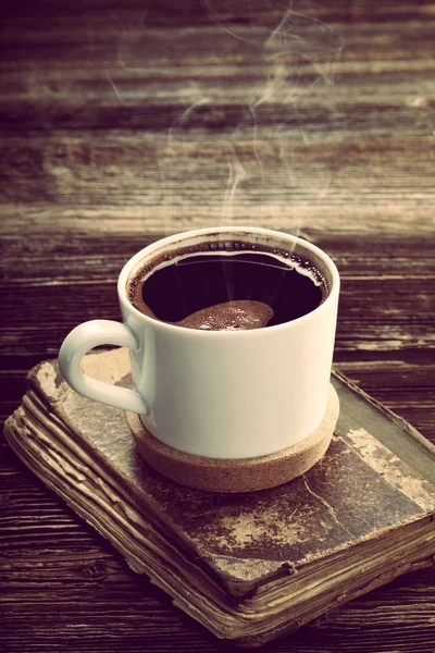 Gammal bok och kopp kaffe på vintage trä bakgrund — Stockfoto