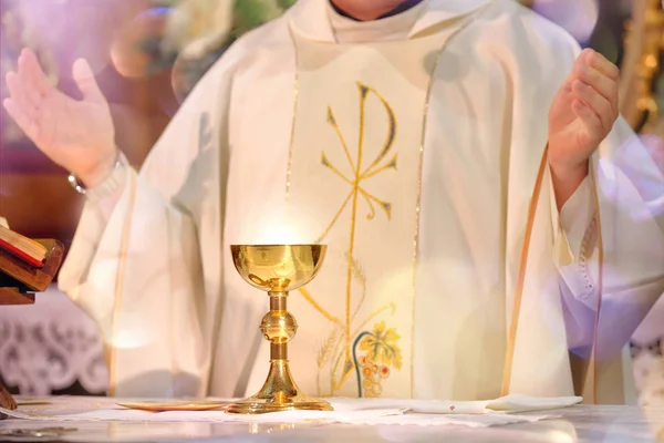 Cálice no altar com raios de luz e Sacerdote celebrar mas — Fotografia de Stock