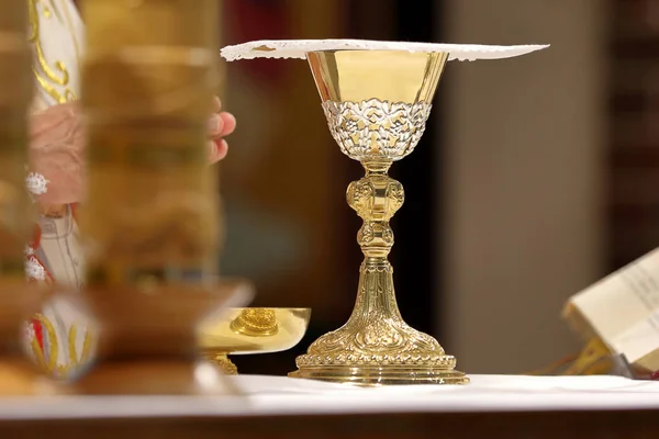 Чаша у алтаря и священник возглавляют мессу — стоковое фото