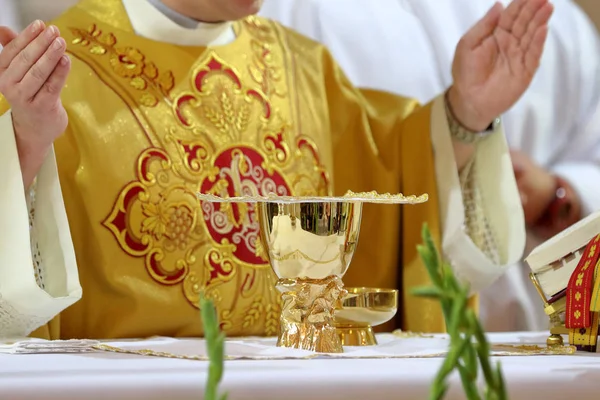 Cálice no altar e sacerdote celebrando missa no backgrou — Fotografia de Stock