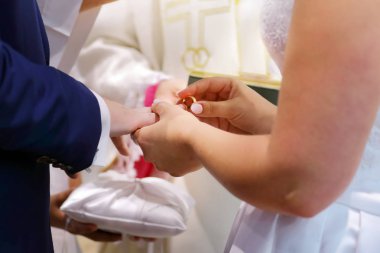 Gelin damat için altın bir alyans koyar