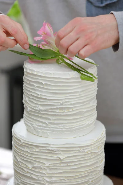 Confeiteiro decora bolo nu de casamento branco — Fotografia de Stock