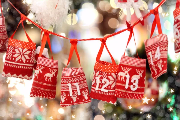 Small bags as Advent calendar with Sweets surprises hanging on a — Stock Photo, Image