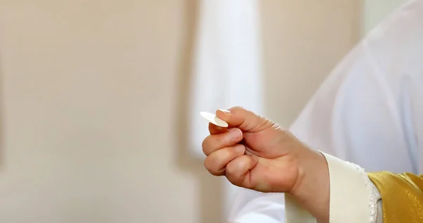 Mão do sacerdote com o Santo Corpo de Cristo e espaço vazio para t — Fotografia de Stock