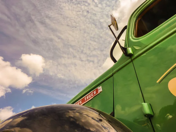 Old green lorry in front of blue sky