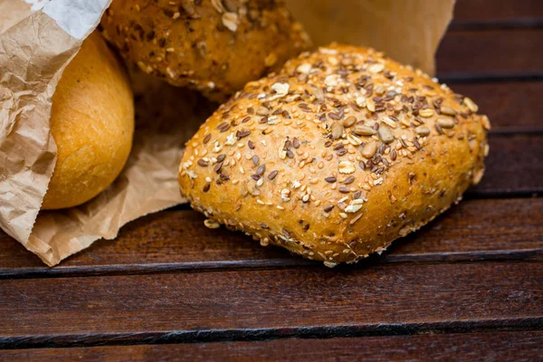 Vers Gebakken Brood Gewikkeld Papier Houten Achtergrond — Stockfoto