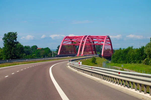 Highway interchange with bridge and sun on the background.