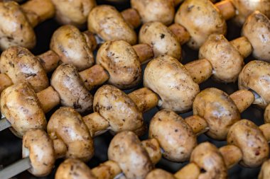 Izgara mantar ve şiş mantar. Daha az pişmiş, yakın plan..