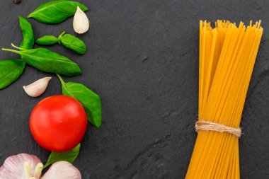 İtalyan yemeği. Makarna malzemelerin üzerine taş tablo. Metin alanı olan Üstten Görünüm.