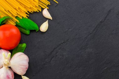 İtalyan yemeği. Makarna malzemelerin üzerine taş tablo. Metin alanı olan Üstten Görünüm.