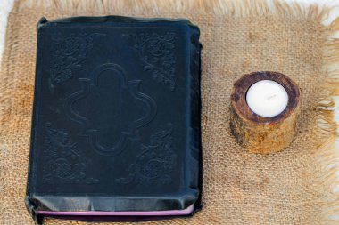 İncil ve çuval bezi peçeteye mum.