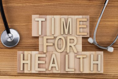 Sağlık - steteskop ile ahşap bloklar vintage mektuplarda metni zamanı. Tıp kavramı.