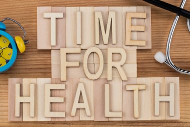 Sağlık - steteskop ve çalar saat ile ahşap bloklar vintage mektuplarda metni zamanı. Tıp kavramı.