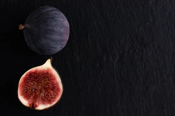 fresh ripe figs on dark background, top view with copy space.