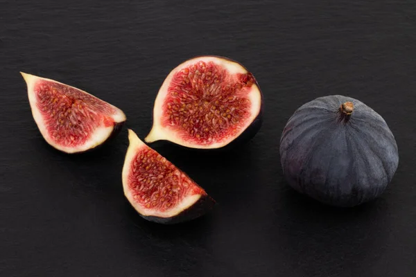 fresh figs on dark background, top view.