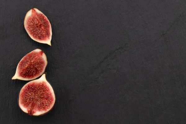 fresh ripe figs on dark background, top view with copy space.