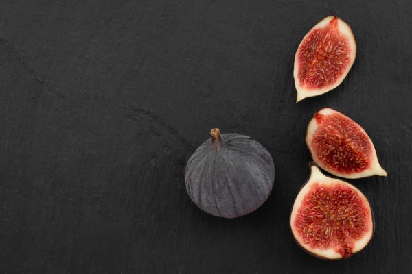 fresh ripe figs on dark background, top view with copy space.