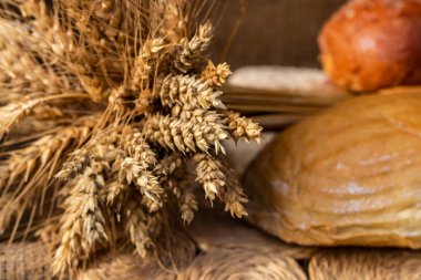 Beyaz buğday ekmek ve bir buğday ile buns tahıl ve buğday spikelets. Uzay kopyalayın. Yakın çekim. Eve ekmek. Ev yapımı.