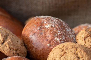 Beyaz buğday ekmek ve bir buğday ile buns tahıl ve buğday spikelets. Uzay kopyalayın. Yakın çekim. Eve ekmek. Ev yapımı.