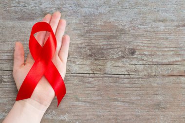 Kırmızı kurdele - ahşap arka plan kopya alanı ile AIDS bilinçlendirme sembolü.