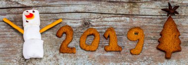 Mutlu yeni yıl 2019 kavramı - komik hatmi kardan adam ve gingerbread ahşap arka plan üzerinde 2019 numarasıyla.