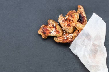 Tavuk kanadı kopya alanı ile koyu arka plan üzerinde pişmiş. Üstten Görünüm.