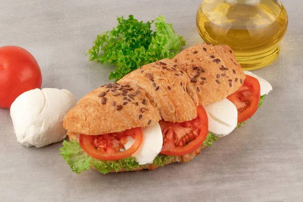 Sandwich de croissant con mozzarella de lechuga y tomate. Saludable s — Foto de Stock
