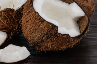 Olgun yarım Hindistan cevizi ahşap bir arka plan üzerinde kesmek.