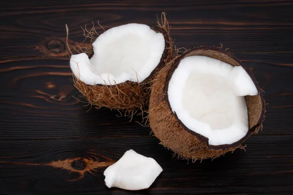 Meia maduro corte de coco em um fundo de madeira — Fotografia de Stock