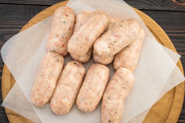 Frische Rohwurst auf dem hölzernen Hintergrund, Draufsicht — Stockfoto