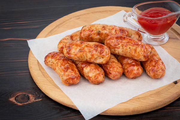 Tasty grilled sausage on the wooden background — Stock Photo, Image