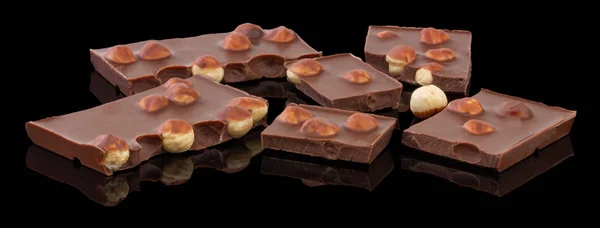 Leite ou chocolate escuro com nozes no fundo preto — Fotografia de Stock